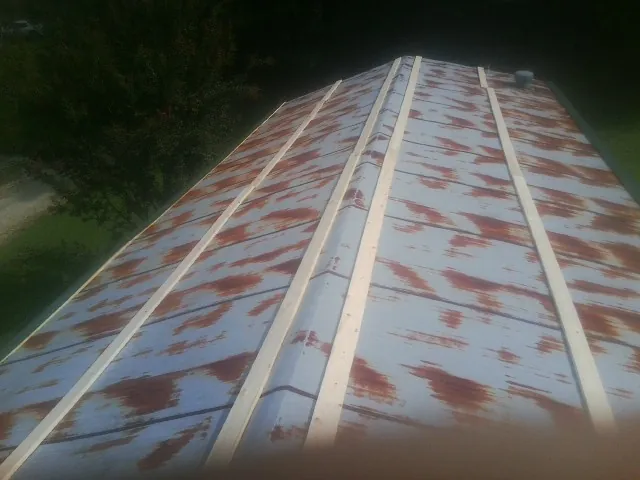 Rusted metal roof panels with new wood purlins before replacement — Storm Damage Roof Repair in Adams by Roofing Brothers
